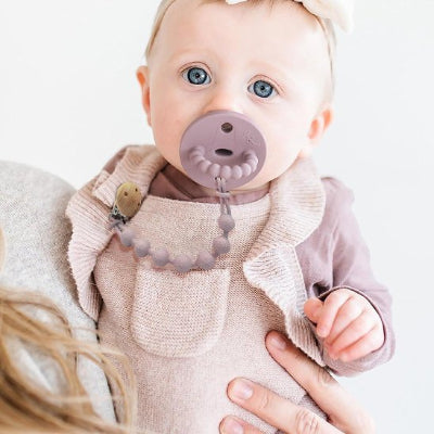 Attache tétine perles en silicone mauve bébé fille à yeux bleu gilet mauve à manche longue