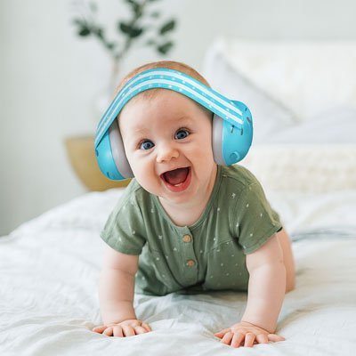 Casque-anti-bruit-bebe-turquoise-bébé-souriant-sur-lit