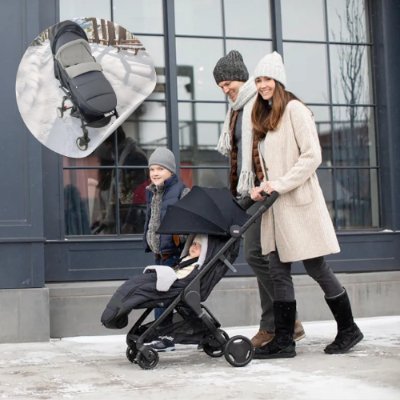 Chancelière-poussette-noire-enveloppant-bébé-avec-sa-famille-en-balade-en-hiver
