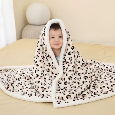 couette-bebe-motif-leopard-couvre-bebe-souriant-assis-sur-un-lit
