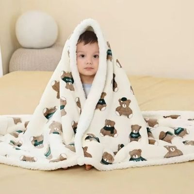 couette-bebe-green-bear-enveloppant-bébé-assis-sur-lit