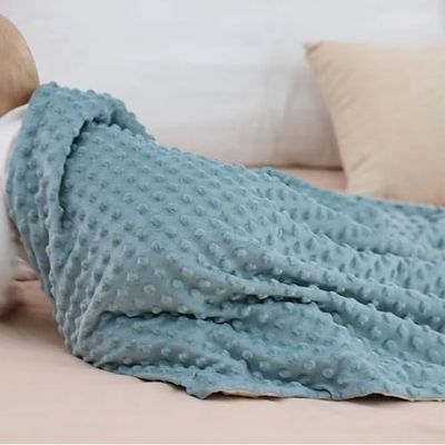 couverture-pour-bebe-bleu-sur-le-dos-de-bébé-sur-un-lit