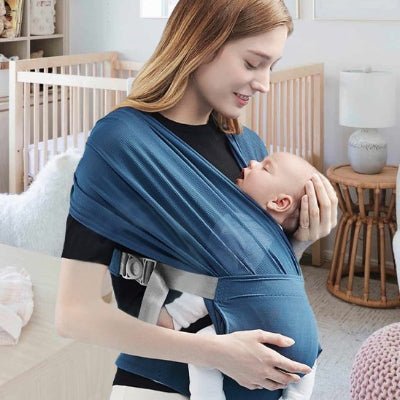 Écharpe de portage ergonomique ceinture grise maman souriante tient la tête de bébé endormi