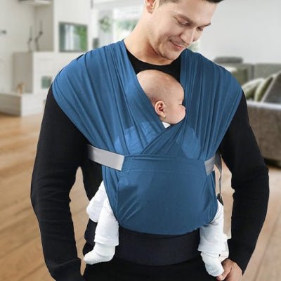 Écharpe de portage ergonomique bleu bébé endormi contre le ventre de papa souriant