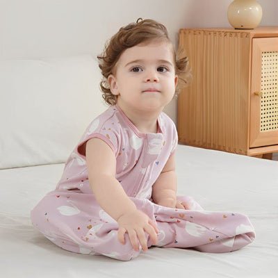 gigoteuse cygones rose bébé assise sur le lit confortablement