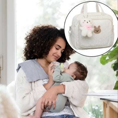 sac-a-langer-compact-blanc-maman allaite bébé avec un biberon