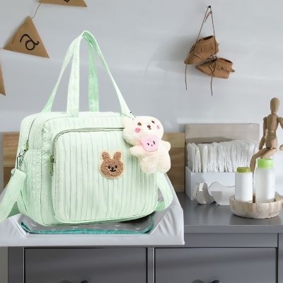sac-à-langer-vert-peluche-rose-couches-chaussures-brunes-poudre-bebe